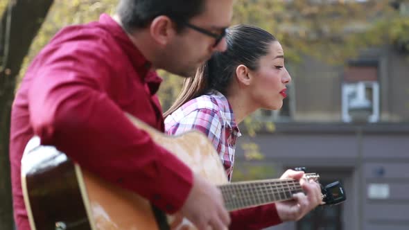 Beautiful Woman Singing While Handsome Man Playing Guitar 2