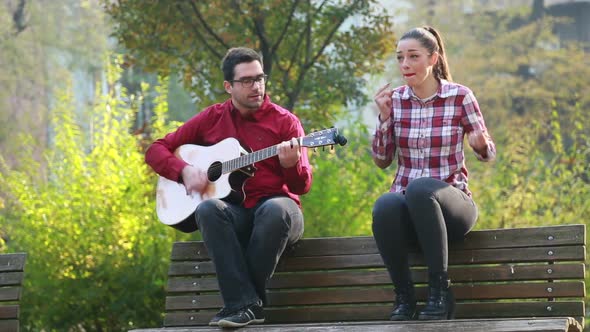 Beautiful Woman Singing While Handsome Man Playing Guitar 4