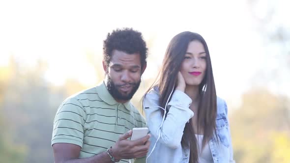 Man And Woman Listening To Music Together, Sharing Earphones 1