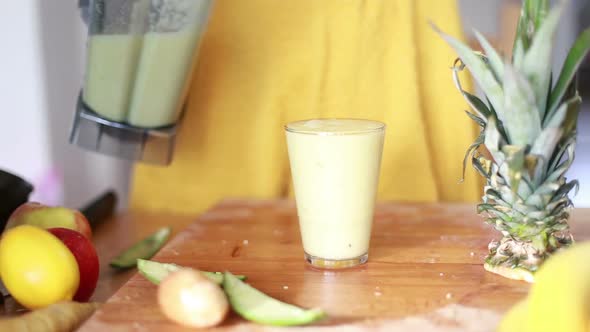 Woman Pouring Fruit Smoothie In Drinking Glass