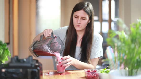 Woman Pouring Fruit Smoothie Into Glass