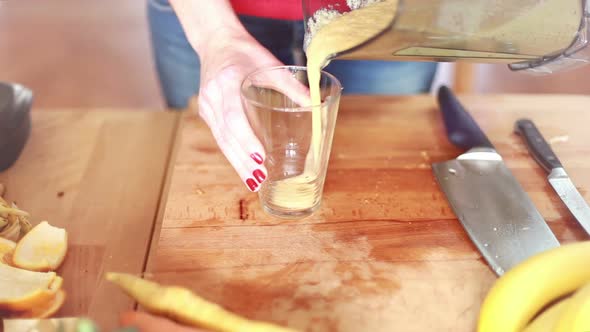 Woman Pouring Smoothie Into Glass 3