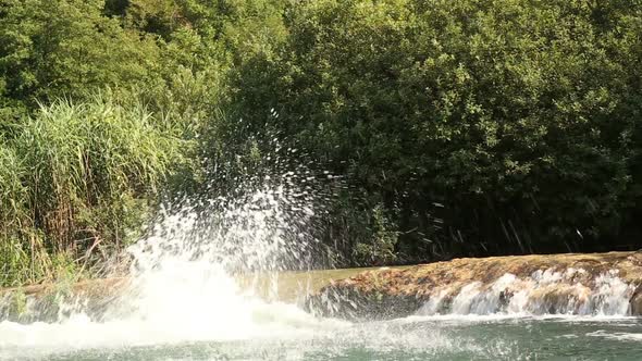 Man Holding Camera While Jumping Into River With Friends 2