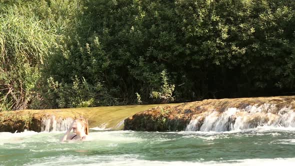 Man Holding Camera While Jumping Into River With Friends 3