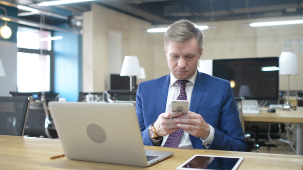 Businessman Typing Text Message on Smartphone