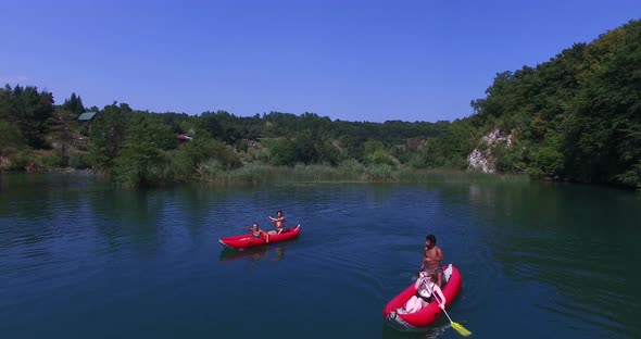 Aerial View Of Friends Paddling Canoe On River