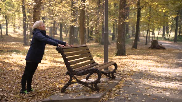 Fit Aged Woman Doing Pushups in Autumn Park