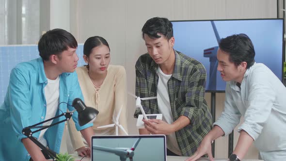 Laptop Showing The Video Of Wind Turbine While Asian Engineers Group Discussing About Work