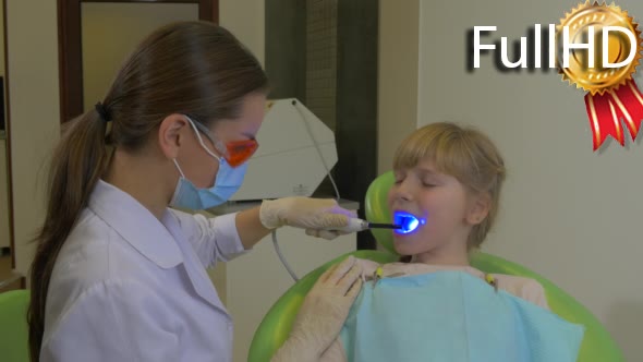 Dentist is Using a uv Lamp Patient is Smiling