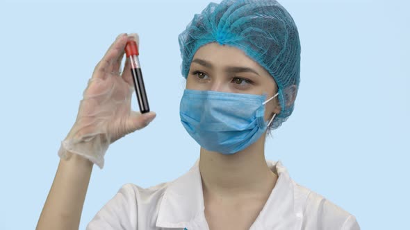 Doctor in Protective Mask Holding Blood Test Capsule