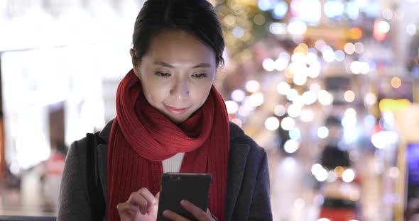 Woman use of mobile phone in city over traffic road background