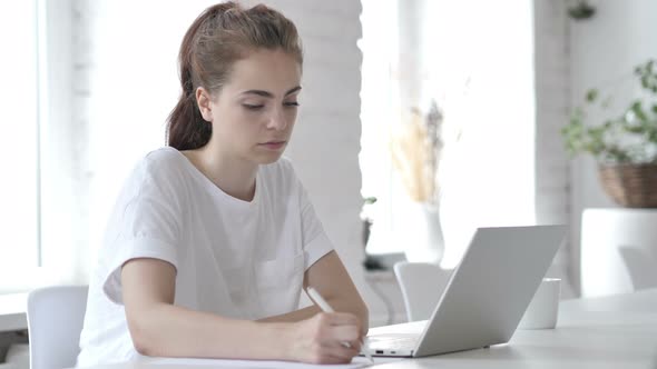 Young Woman Writing on Papers