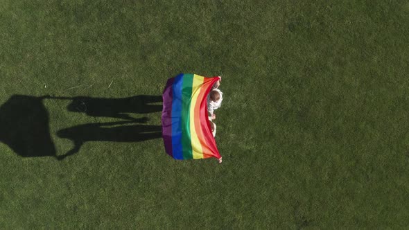 Drone Shot of Lgbt Flag Fluttering in Female Hands