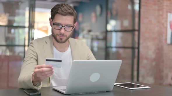 Successful Online Payment on Laptop By Young Man