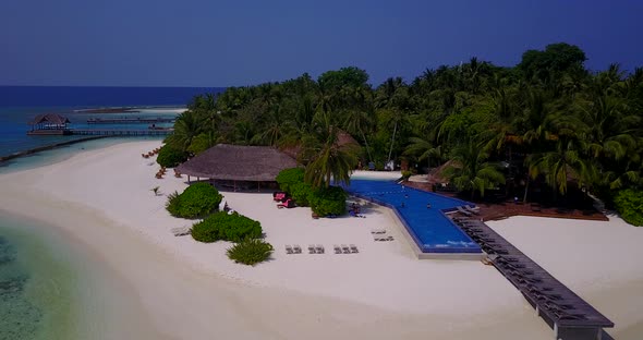 Wide overhead clean view of a white sandy paradise beach and aqua turquoise water background in colo