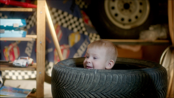 Boy Hiding In Pile Of Tyres