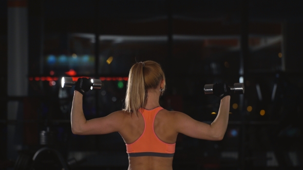 Woman Doing Exercise With Dumbbells On Shoulders