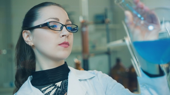 Woman Examine Flask In a Laboratory 
