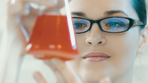 Woman Look At Flask In a Laboratory 