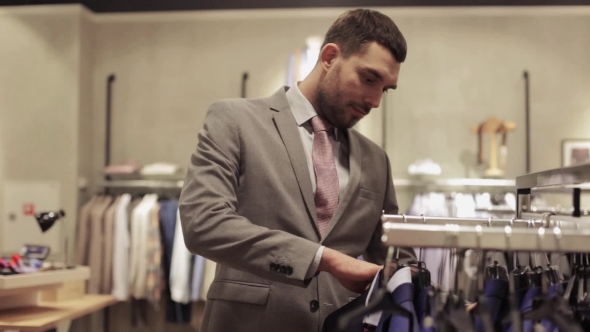 Young Man Choosing Clothes In Clothing Store 30