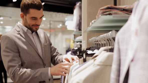 Young Man Choosing Clothes In Clothing Store 22