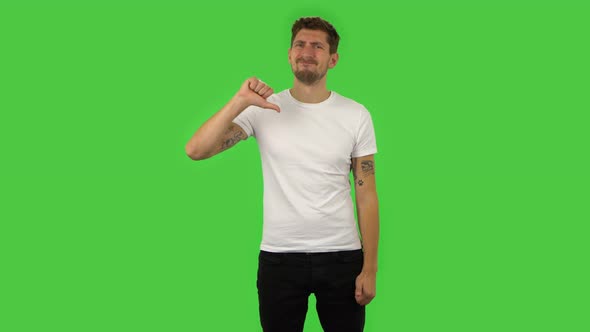 Confident Guy Is Showing Thumbs Down Gesture. Green Screen