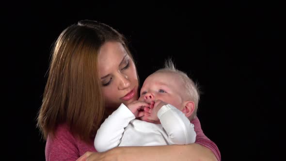 Mother Tenderly Kissing Her Cute Newborn Baby Son. Black. Close Up