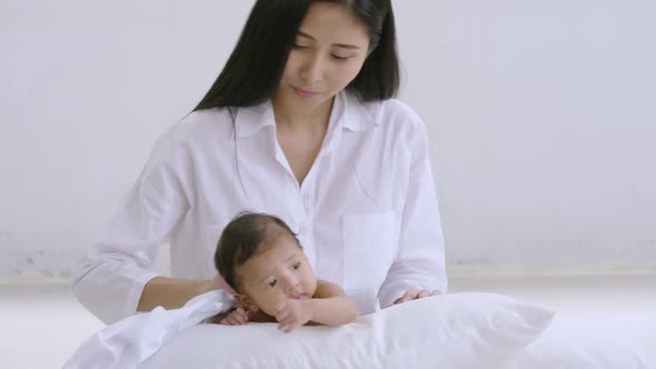 Beautiful young mother with her newborn baby in bedroom