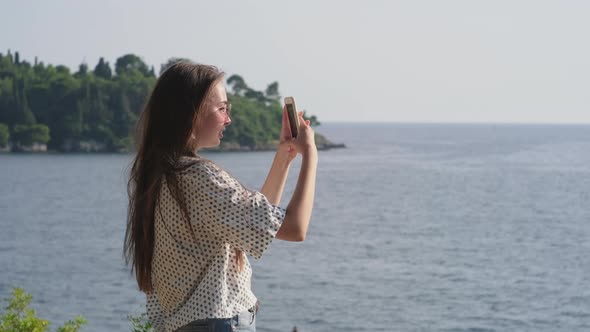 Girl with Mobile Taking Picturesque Sea Shots
