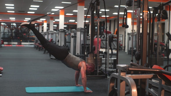 A Man Makes Multifunctional Exercises In The Simulator