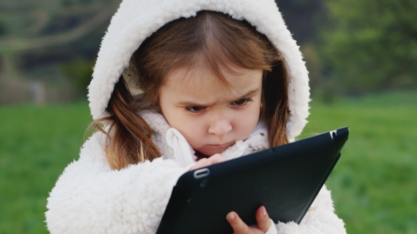 Very Serious Girl 3 Years Old With a Tablet