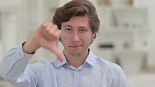 Disappointed Casual Young Man Doing Thumbs Down