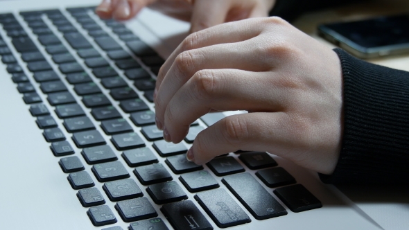 Femine Hands Typing On The Keyboard Of a Laptop