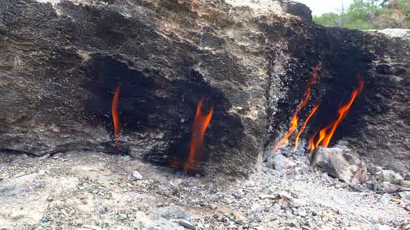 Flame of Methane Underground Emerges From Crack Between Rocks and Burns to Earth