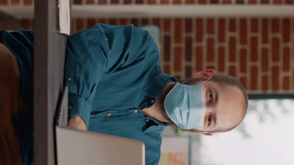 Portrait of Business Man Wearing Face Mask and Using Laptop