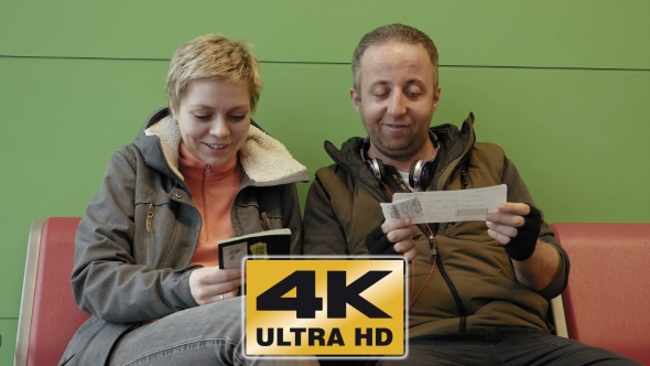 Couple Waiting At Airport Terminal With Tickets