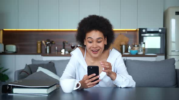 Adorable Mixed Race African American Woman Enthusiastically Typing Text on Her Smartphone Smiling