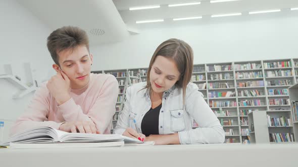 Low Angle Shot of Two College Friends Enjoying Studying Together at the Library