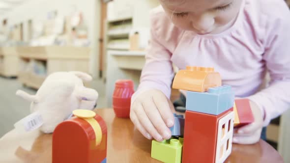 Slow motion. Toddler girl playing with building blocks.