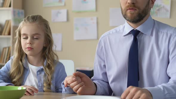 Father and Daughter Praying Before Meal Holding Hands, Religious Education