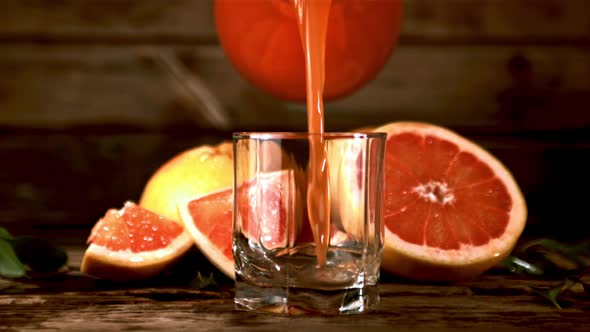 Super Slow Motion Grapefruit Juice Poured Into a Glass of Jug