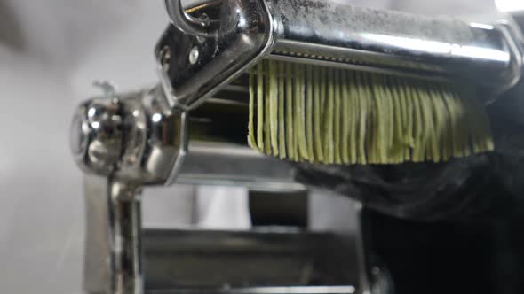 Traditional Italian Cuisine. Making Homemade Pasta, Close-up of Chef Makes Pasta Using Steel Machine