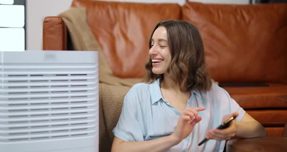 Woman with Air Purifier or Conditioner at Home