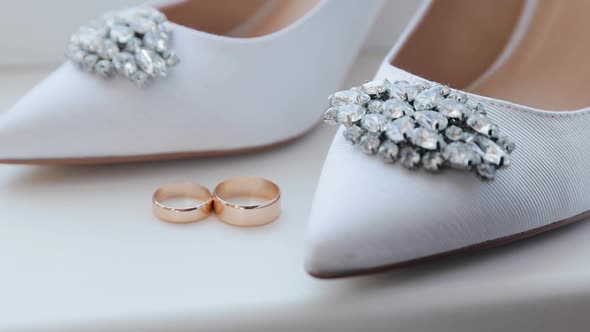 Wedding rings and bridal shoes. Pair of marriage symbols. Matrimony symbol