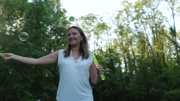 Slow Motion Footage of Beautiful Woman Blowing Soap Bubbles