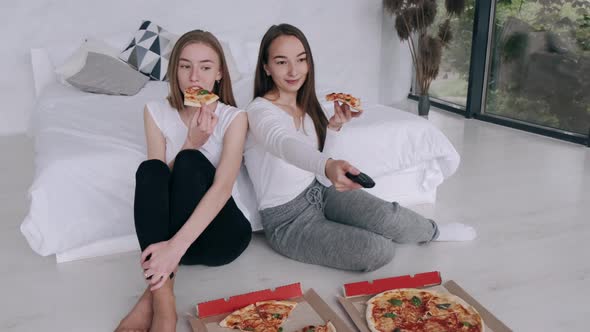 Girls Friends Eats Pizza and Watching TV at Home