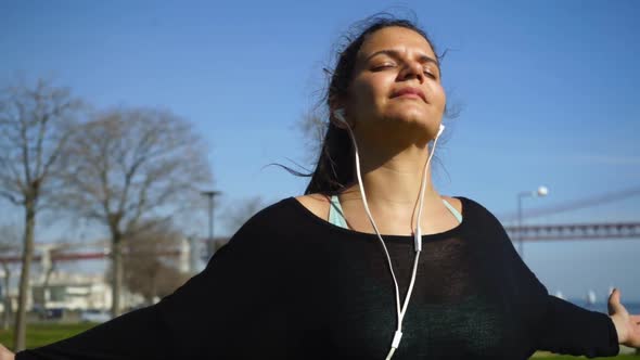 Relaxed Sporty Girl with Closed Eyes Training in Park