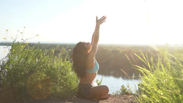 Healthy Woman Meditating in Pose Lotus Over at Sunset. Slow Motion