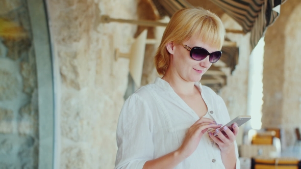 Woman Tourist Writing Sms On a Background Of a Typical Italian District