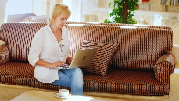 Attractive Woman Working With a Laptop In The Lobby